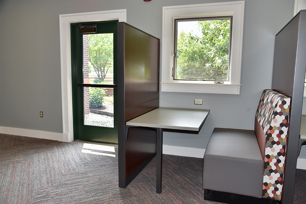 New half bench seat and table in the Adult Area next to a newly created window and exit door to the Bittersweet Branch Courtyard