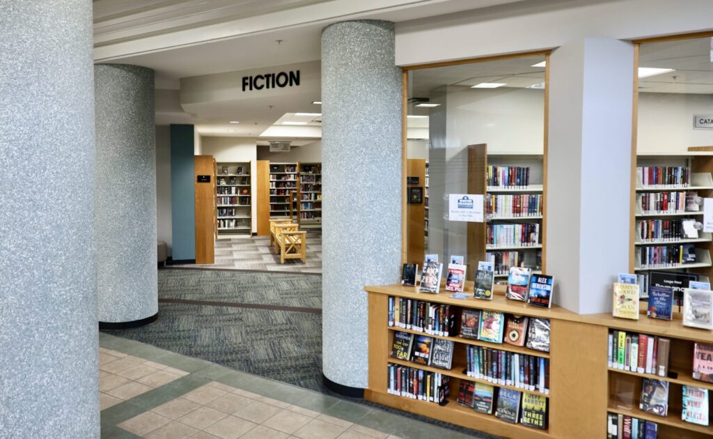 The Adult Fiction area at the downtown Mishawaka Library with new LED energy-efficient lighting upgrades. The text above the entrance to the area reads, ‘FICTION’.  