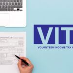 Computer, calculator, notepad a person’s hand holding a pen and a 2023 1040 tax form. Text image, ‘VITA VOLUNTEER INCOME TAX ASSISTANCE Get your taxes prepared for free through the IRS VITA program! Call (574) 800-1361 to see if you qualify and/or to schedule your appointment today! Tuesdays: February 6 - April 9 Mishawaka Library 209 Lincolnway East *By Appointment Only’