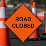 Reflective traffic cones on the street and image text, ’ROAD CLOSED’