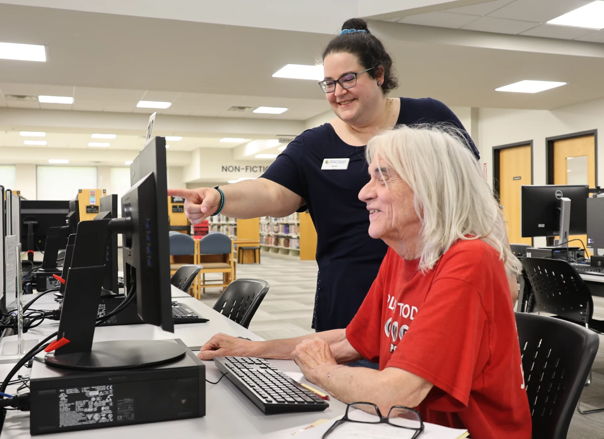 Photo_Tech-Assit A woman helping a man navigate a computer at the Mishawaka Library computer lab.