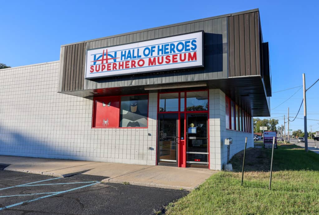 Hall of Heroes Superhero Museum front entrance with red-framed glass doors and windows.