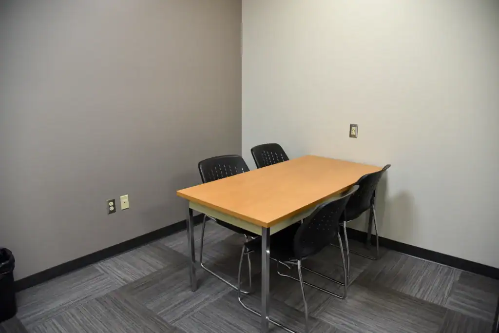 The Mishawaka Library Adult Study Room Four containing a table and four chairs. Both walls have power outlets.