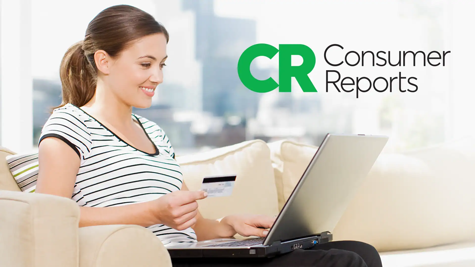 A woman sits on a couch, smiling while holding a credit card and using a laptop. The Consumer Reports logo is visible, conveying a positive online shopping context.